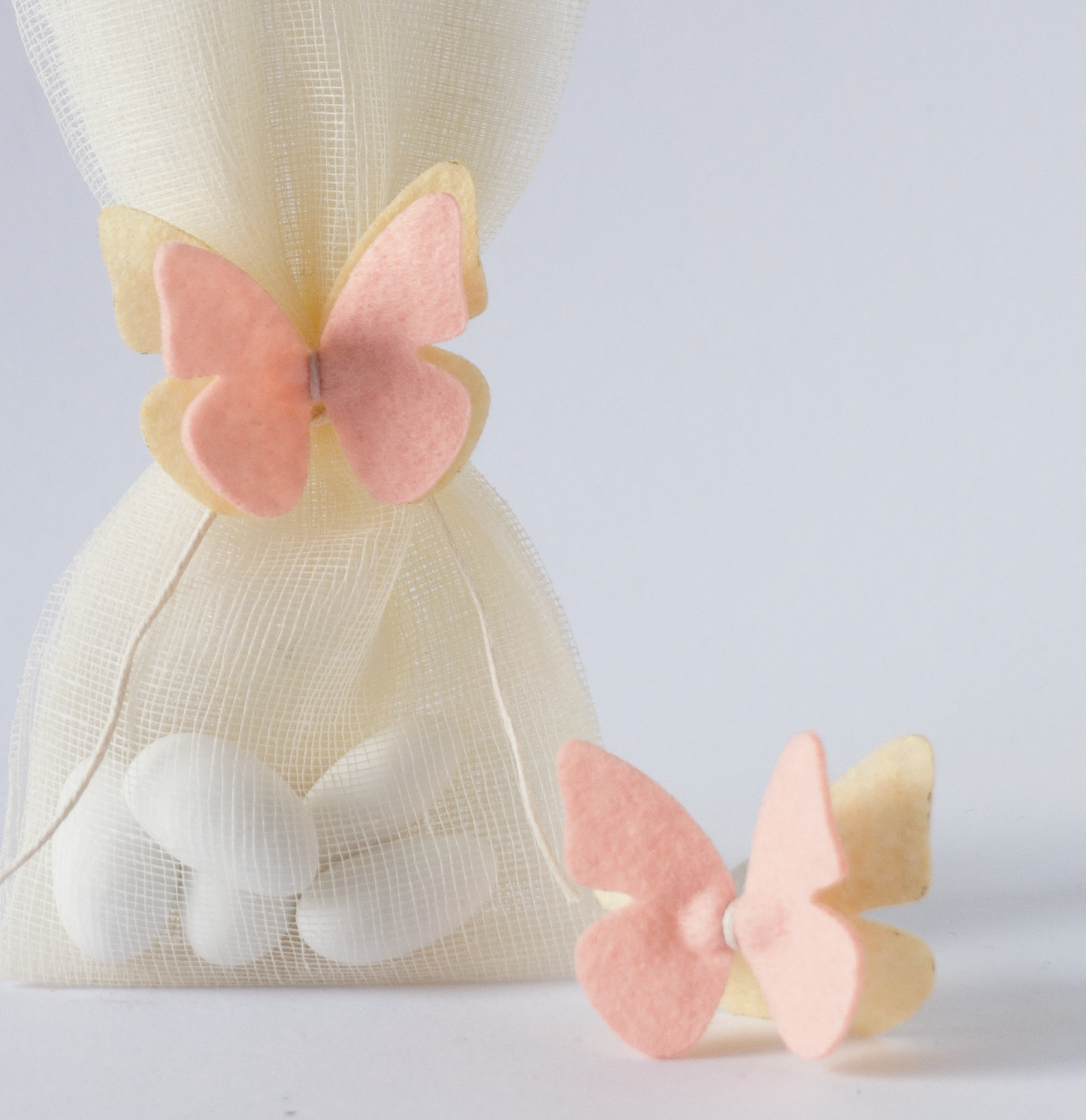 Elegant μπομπονιέρα βάπτισης με ροζ butterfly hair accessory και soft αποχρώσεις